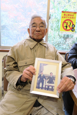 写真を掲げる加藤さん